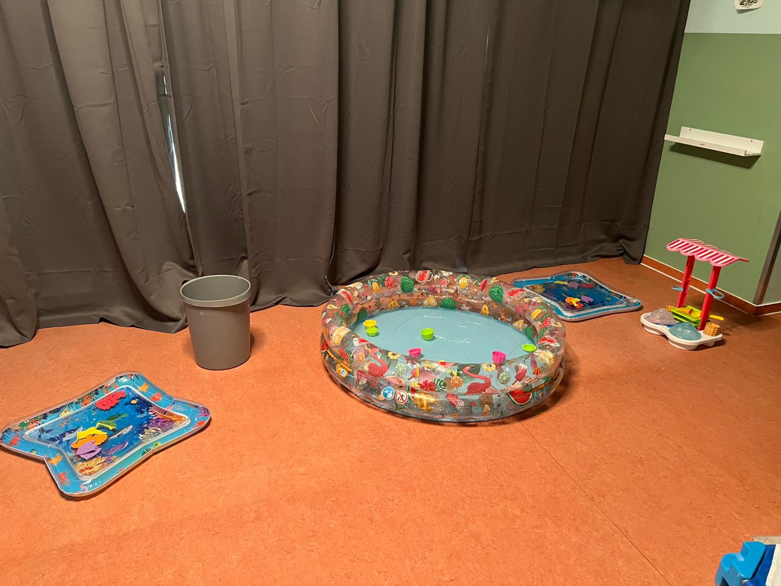 Planschbecken und Wasserspielzeug im Gruppenraum als Abkühlung bei Sommerhitze