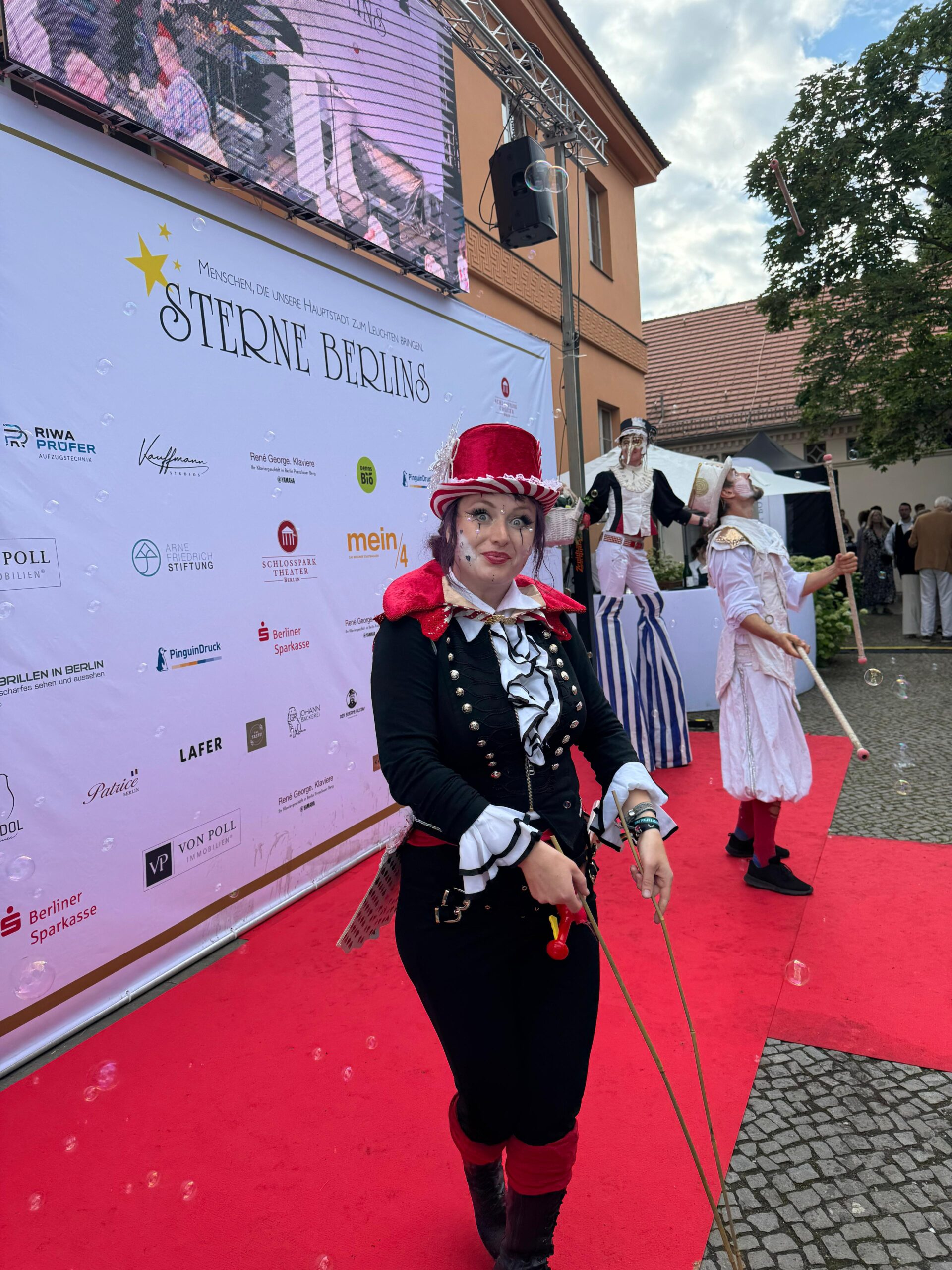 Walking Acts mit aufwendigen Kostümen begrüßen Gäste beim Sommerfest Sterne Berlins 2025