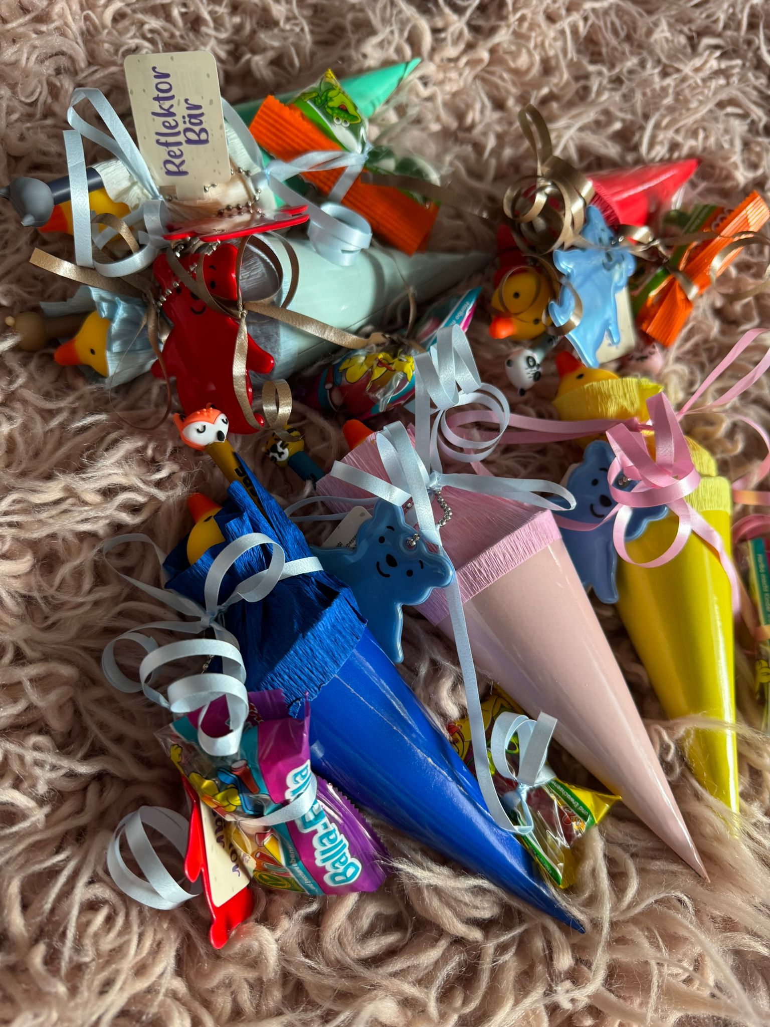 Kleine bunte Zuckertüten mit Süßigkeiten und Anhängern – ein Kita-Jahr geht zu Ende
